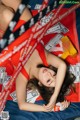 A woman laying on top of a bed covered in money.