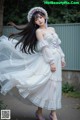 A woman in a white dress with a flower crown on her head.