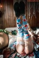 A woman laying on a bed with her legs up in the air.