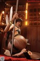 A woman in fishnet stockings holding a sword in a bar.