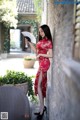 A woman in a red dress holding a fan.