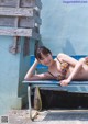 A woman in a bikini laying on a bench.